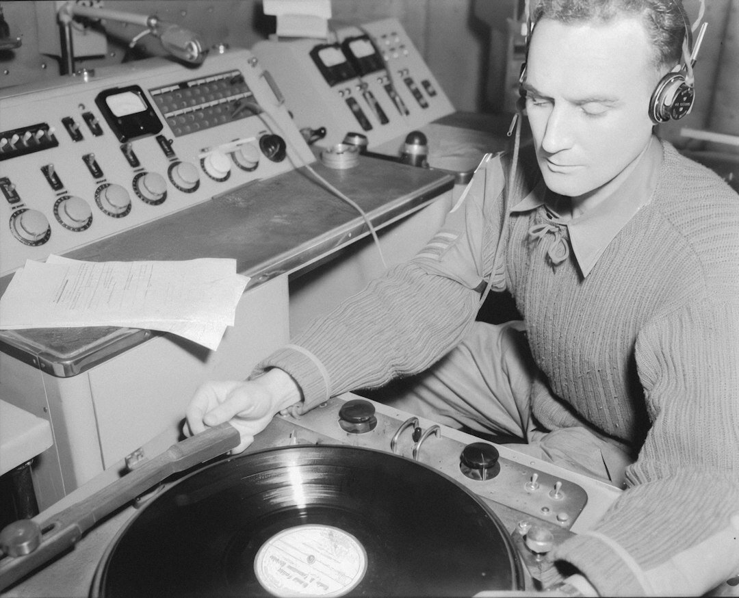 Radio presenter speaking into a vintage microphone in a broadcast studio