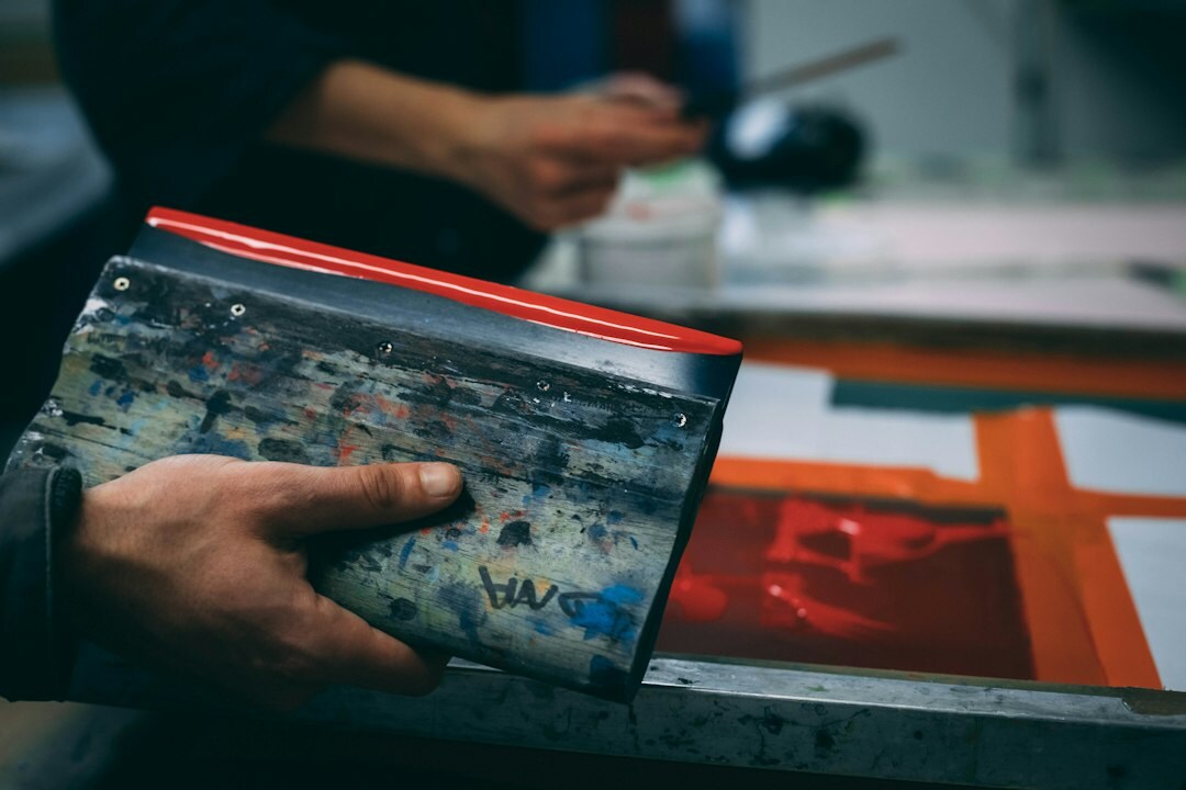 Graphic designer arranging vintage advertising posters and layout sheets on a drafting table